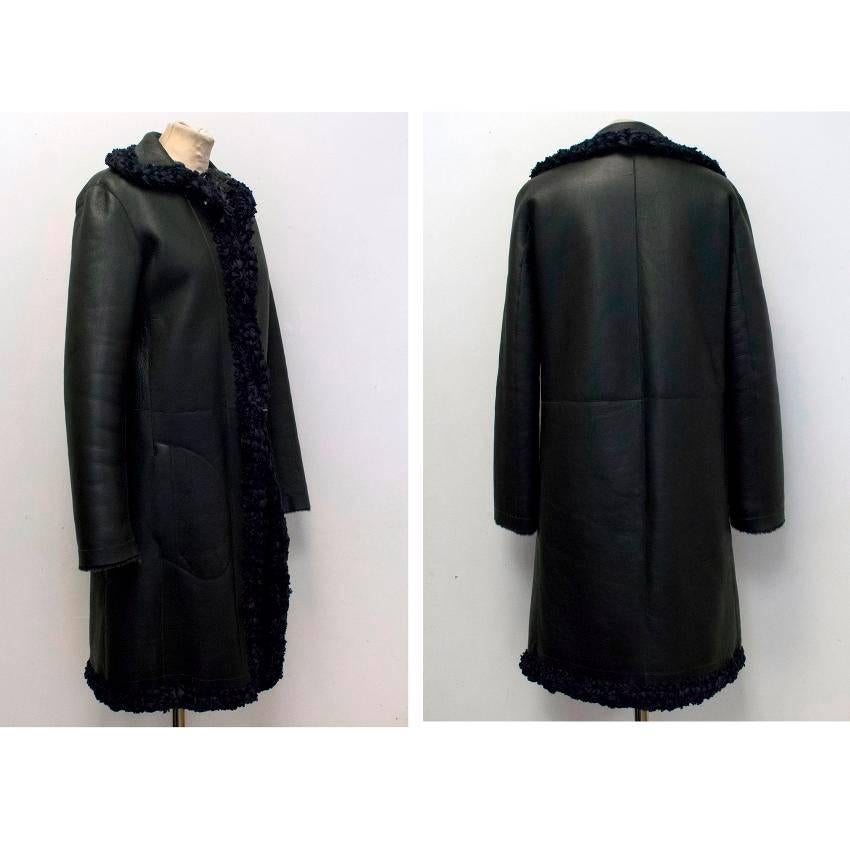 Celine leather and shearling reversible coat with two pockets on the shearling side and rimmed with navy pleated ribbon details around the collar, hem and at the front with sown in metal hooks and loops to fasten the coat. 

There is some minor