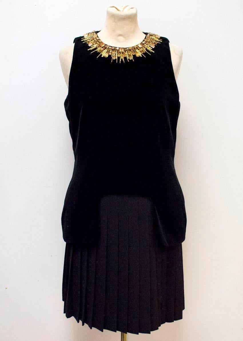 Alexander McQueen black velvet and wool sleeveless dress. The upper half of the dress is velvet material, featuring gold embellishments around the neckline, and the bottom half of the dress is a pleated wool skirt. Features a concealed zip down the
