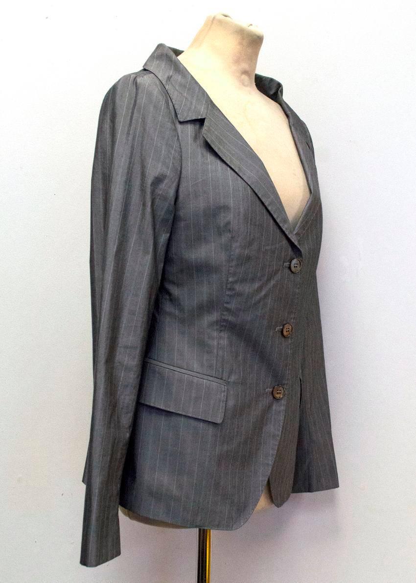 Alexander McQueen trouser suit set in grey with subtle pinstripes, and with a very slight shine to the fabric. 
The blazer is slim fitting and single breasted, with full length sleeves, a single vent, wide-set neckline with a notch lapel, and grey
