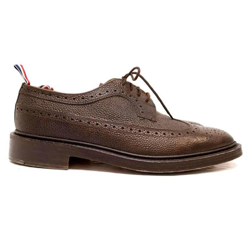 Thom Browne brown classic brogue with leather soles. Made from brown pebbled grain calfskin leather, red, white and blue pull tab, leather sole
metal heel and top taps. 

Signs of wear to the soles.

Made in England.

Condition:9.5/10

Size EU: