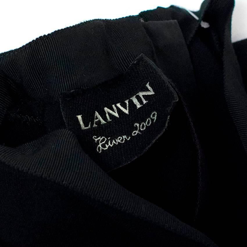 Lanvin black knee length, wool blend pencil dress with a high neck. 
Features capped sleeves and a ruched detail at the front.
Fastens at the back with a concealed zip.
The dress is fitted and made out of stretchy material. 

There is a faint