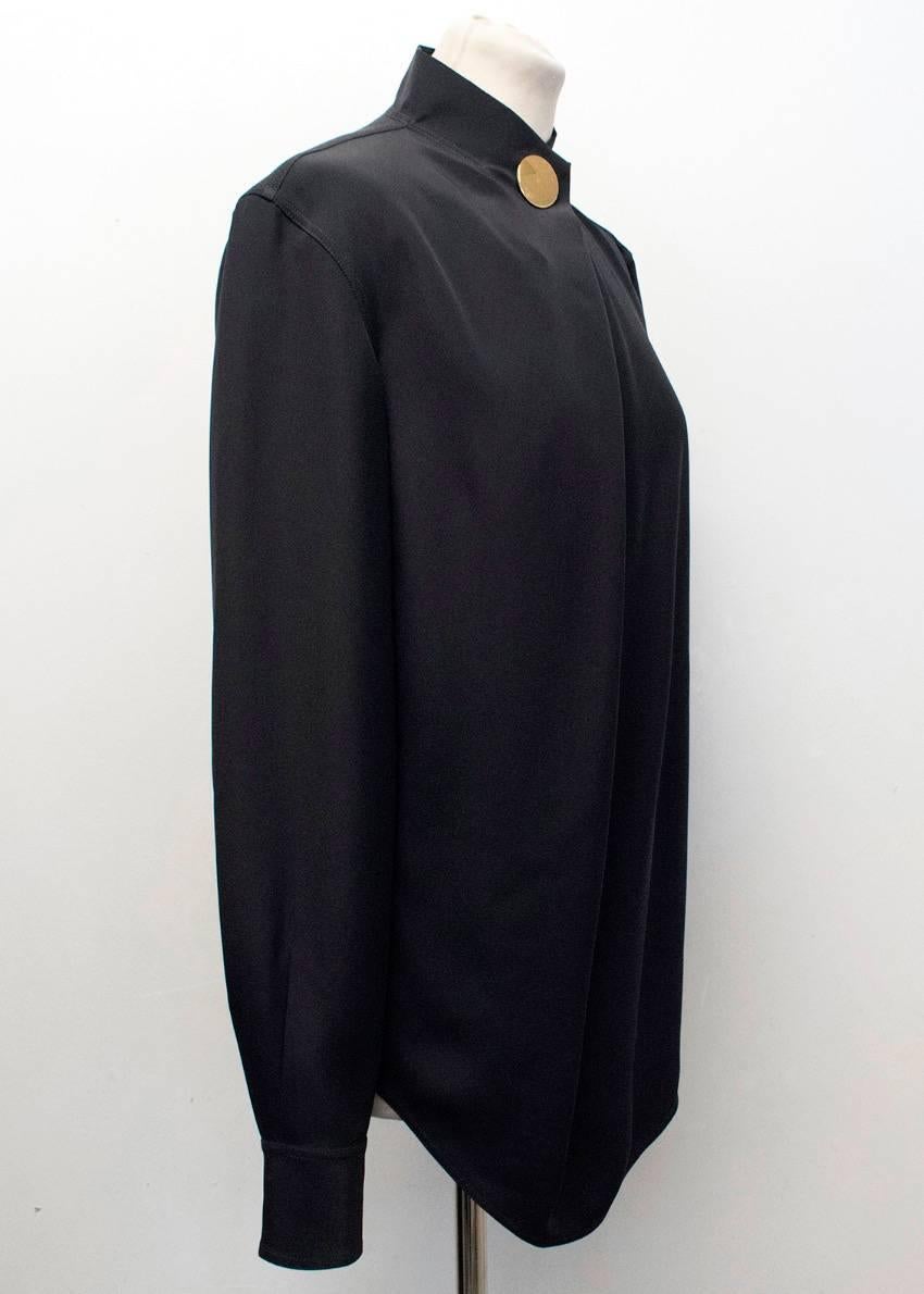 Celine black mulberry silk shirt. Features long sleeves, a high neckline with a large gold tone button detail, rounded hem, button fastened cuffs and box pleated detail at the back of shirt.

There is tarnish to the hardware please see image 5,