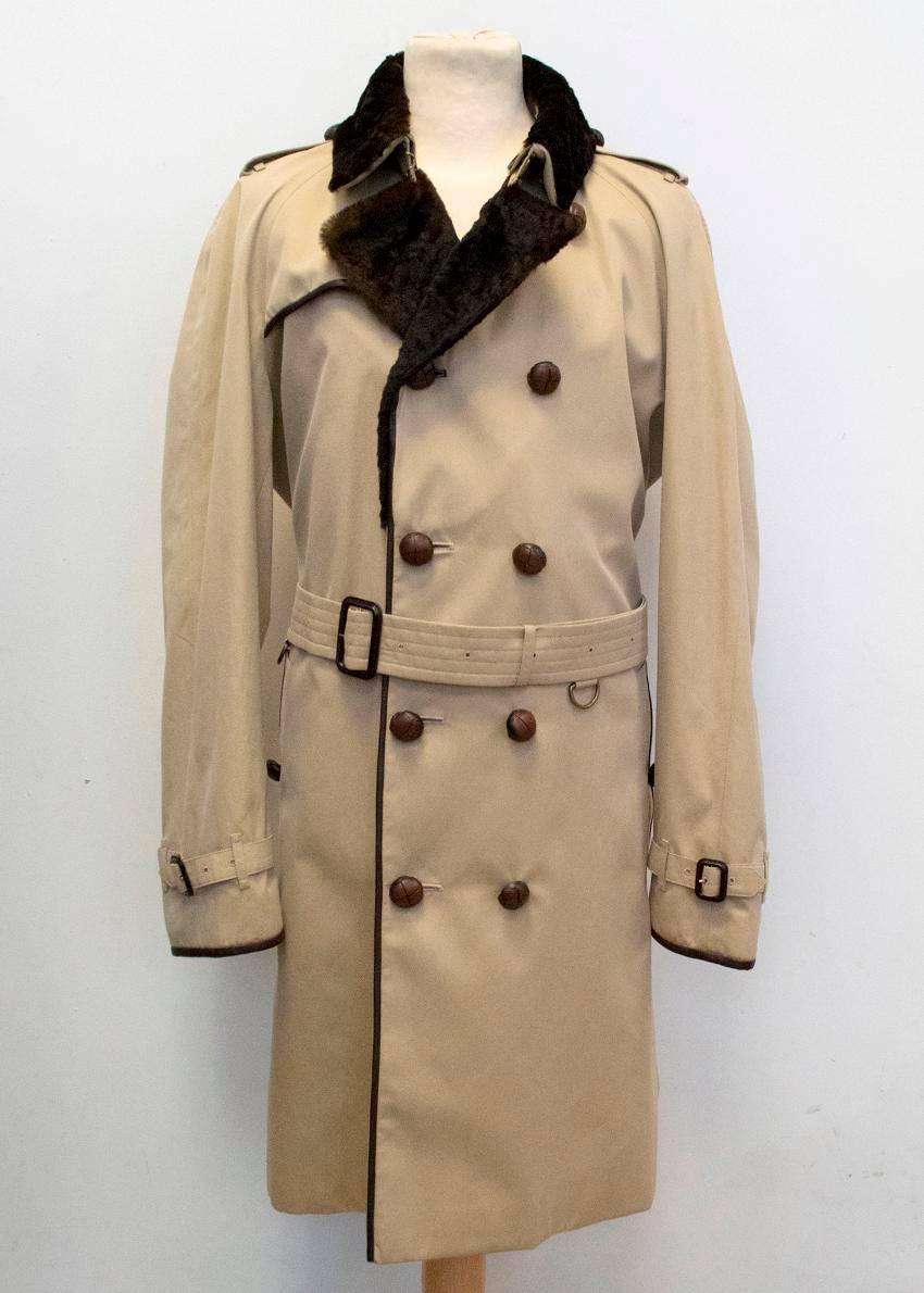 Burberry dark beige 'Kensington' fit tailored trench coat with a detachable rabbit fur collar, rabbit fur lapels and lambskin leather trim. The coat is double breasted with dark brown button detailing, epaulettes, two pockets, buckle detail on the