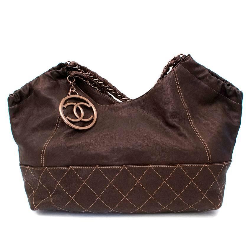 Chanel brown shoulder bag with bronze hardware. 

Features quilted leather bottom, snap closure, chain straps, and large interlocking 