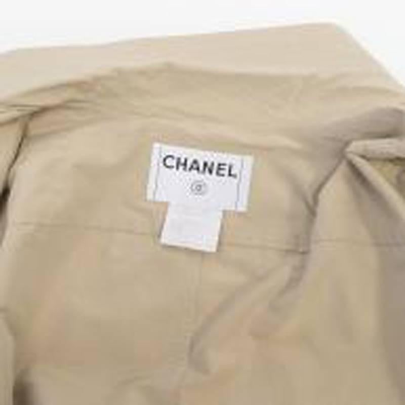 Chanel beige silk trench coat in a contemporary asymmetric style featuring a double-layer collar, waist belt and front flap pockets in a midi length.

Size: US 4, XS
Measurements: Approx. Length: 100cm Shoulder: 58cm Sleeve: 61cm Waist: