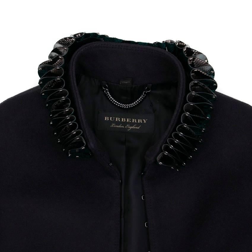 Burberry navy blue wool jacket. Turquoise, grey and black layered snake detail on the collar. Hook and eye fastening down the center. Detachable collar.

Condition: 10/10

Approx.
Shoulder Width: 40 Cm 
Sleeve: 51 Cm 
Bust: 35 Cm 
Length: 45 Cm

US