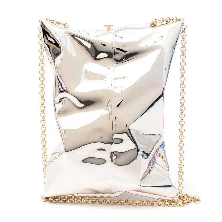 Anya Hindmarch silver crisp packet clutch with detachable chain. The item has a push clasp-fastening at the top, with gold-tone metal hardware. Soft suede lining accompanied by a leather patch logo. 

Measurements: Approx. Chain: 61cm Length: 16.5cm