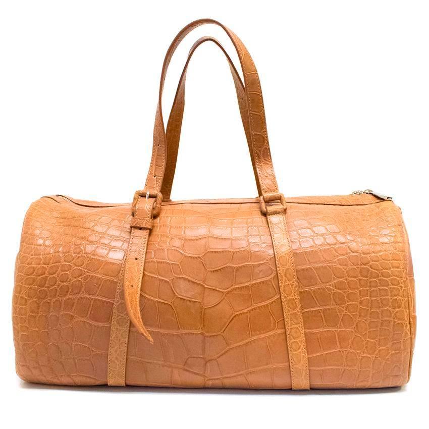 Ethan K tan crocodile holdall in a medium size featuring silver hardware, top handles and a detachable shoulder strap. The interior is fully lined and has one main compartment with three side pockets. The bag also comes with a small silver mirror.