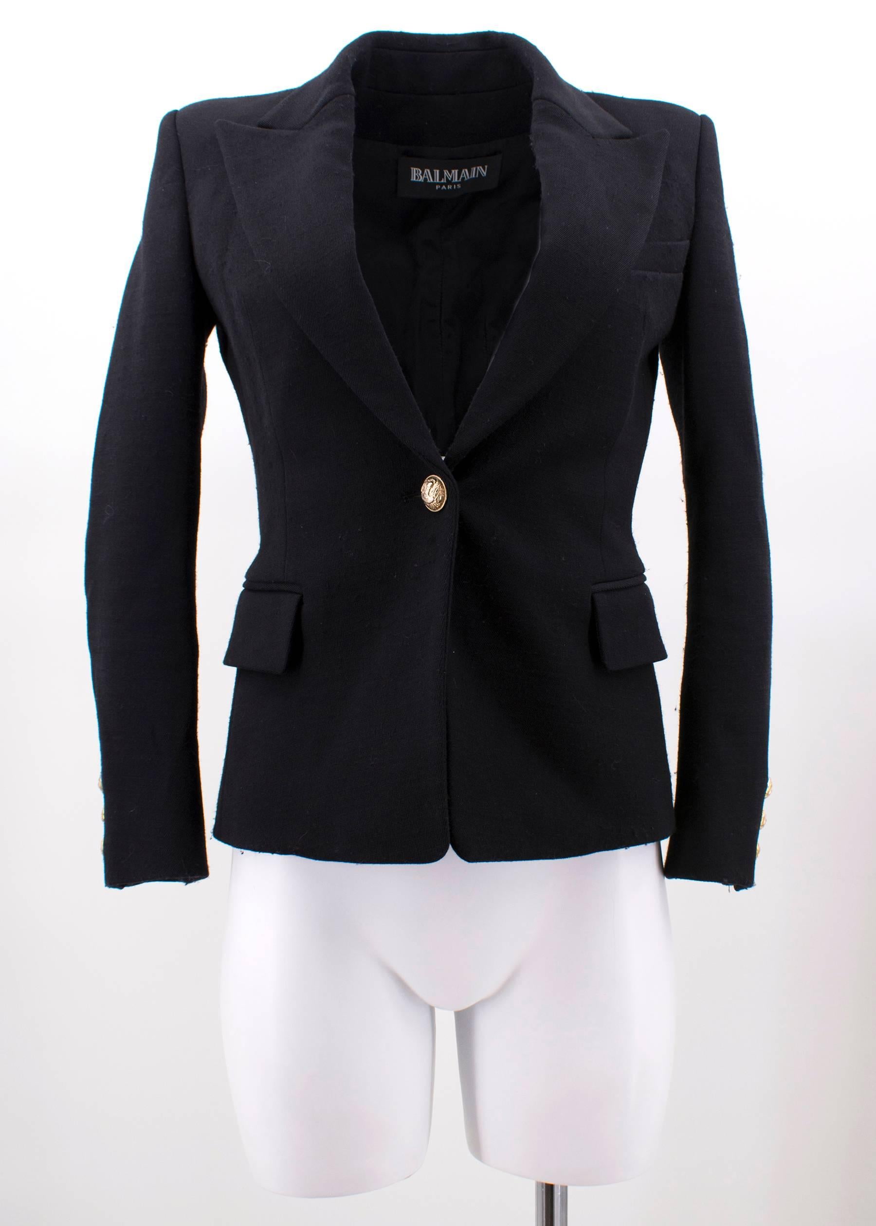 Balmain black wool blazer featuring padded shoulders, one button fastening through front, two flap pockets, one slit pocket and gold-tone embossed button.

Fabrics: 96% Wool, 2% Elastan and 2% Polyamide.

Approx Measurements: 
Shoulders- 38cm