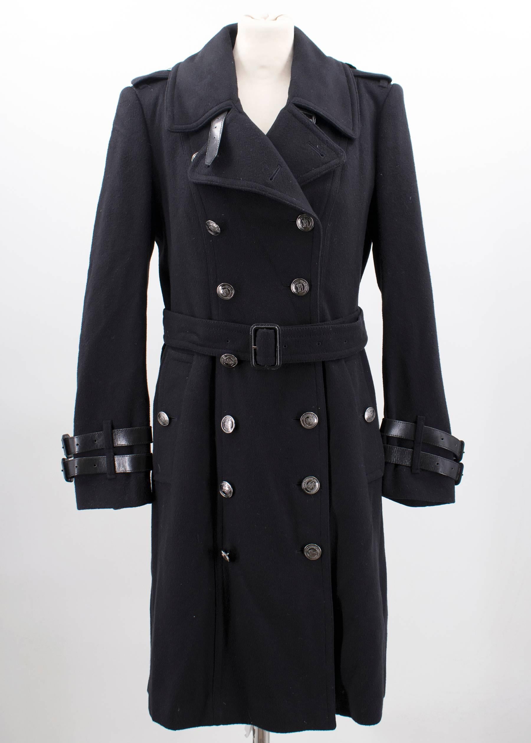 Double breasted trench coat featuring black logo buttons, a waist belt and leather trimmings on the sleeves.

Please note, these items are pre-owned and may show signs of being stored even when unworn and unused. This is reflected within the