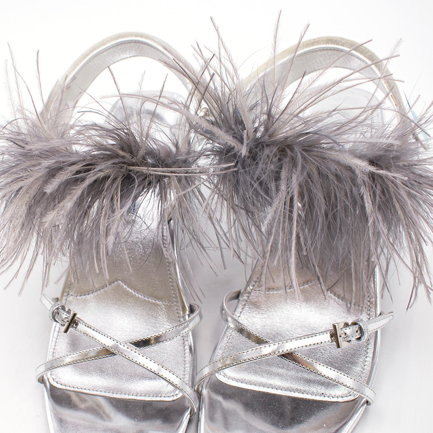 Prada Strap Feather Slingback Sandals

- Criss-cross straps 
- Open toe
- Slingback style with contrast velcro straps
- Grey ostrich feather detailing around the front of the ankle 
- Statement, abstract kitten heel

Sizing: US 9.5

Approx.
Heel