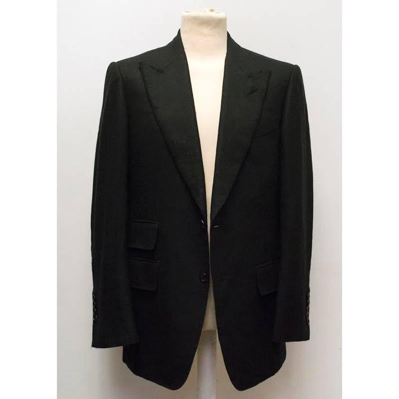 Tom Ford black cashmere sport coat with peak lapels, two button closure, one chest pocket and three non-functioning pockets. Classic fit, fully lined and medium weight, the coat features a double vented back and is soft to the touch with padded