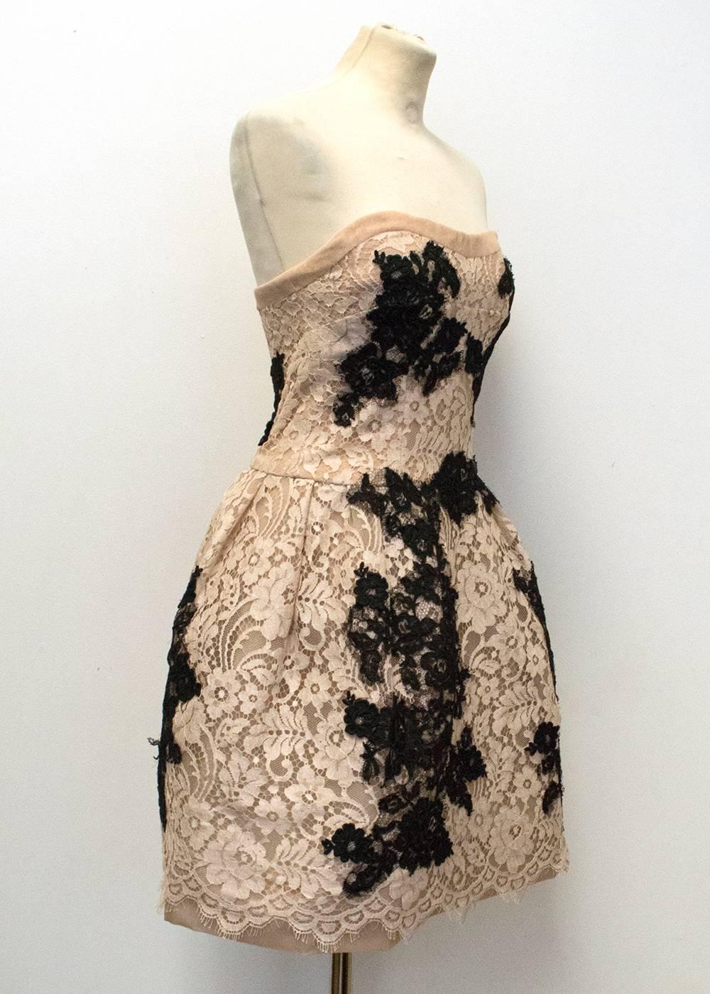 Dolce and Gabbana couture strapless mini dress featuring a nude underlay with Black and white floral lace applique. The bodice of the dress is boned and the skirt has volume created with horse hair facing. Light weight and slim fit with a concealed