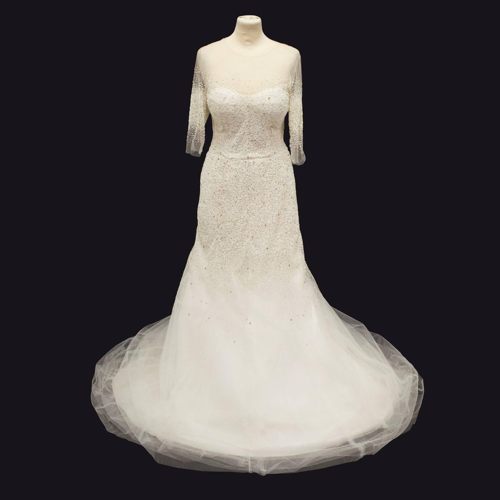 Monique Lhuillier custom made hand embellished wedding dress, with 10 layers of hem fabric. A myriad of netted mesh and silk blended  fabric with a sheer overlay embellished with beads, sequins and Swarovski crystals. 3/4 length sleeves with