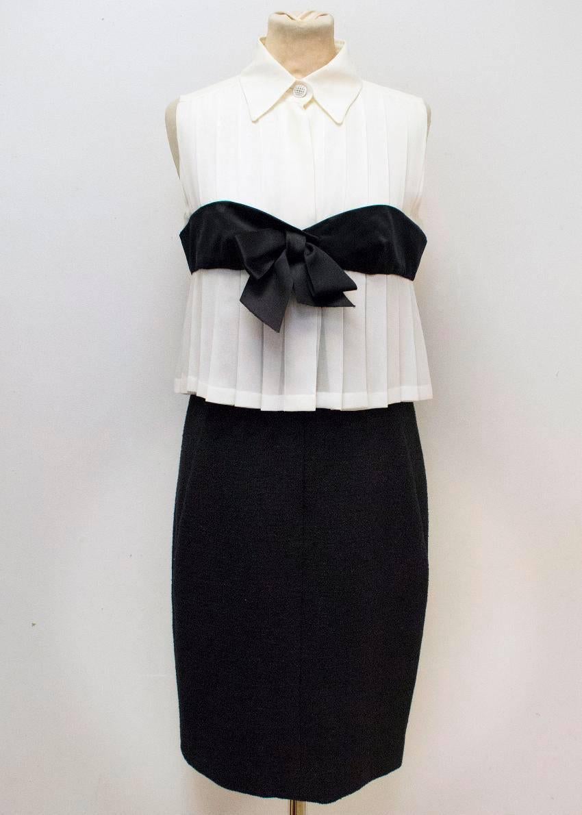 Chanel black and cream pencil dress. Made to look like a blouse and skirt. The upper part is a cream collared silk pleated top with a white checked metallic button at the collar. Attached black satin bow detail with a straight fitted wool