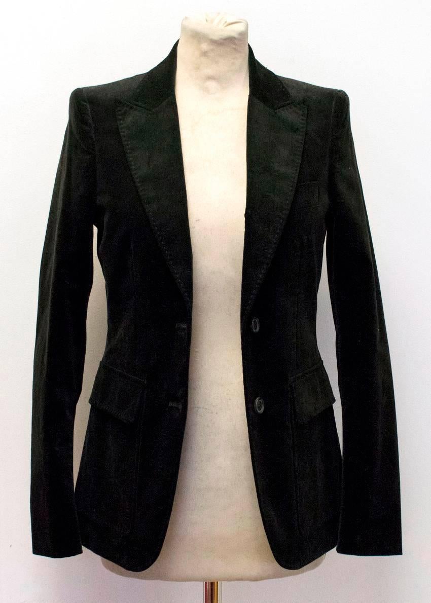 Gucci brown velvet blazer. This blazer features a peak lapel and is single breasted with 2 buttons in the center. There are flap pockets on each front side and a pocket on the left chest. This blazer is long sleeved, with 3 non-functioning buttons