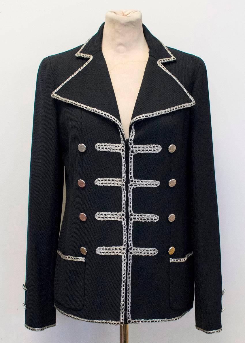 Chanel black military blazer. This blazer is double breasted and features silver embroidered detailing and silver buttons. Down the center, there are snap buttons. There is a pocket on each front side. This blazer is fully lined. At the wrists,