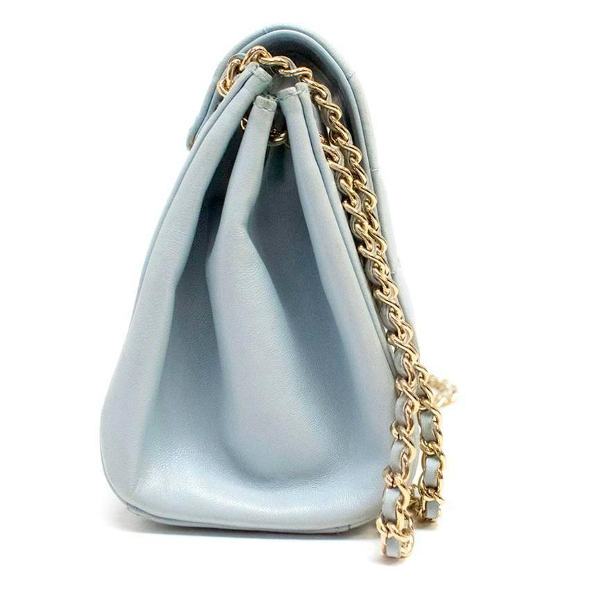 Chanel light blue shoulder bag with a gold toned and leather chain, a quilted foldover closure, and a gold toned twist clasp featuring engraved branding.

The inside is lined with matching light blue leather and features a side pocket. 

Comes with