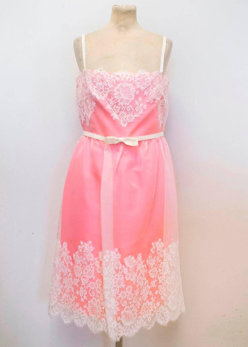 Valentino pink mid length dress with a fitted body and a full skirt. The main body of the dress is pink, with a cream sheer layer over the top, and cream lace detailing around the bust and hem. It features thin cream shoulder straps and an