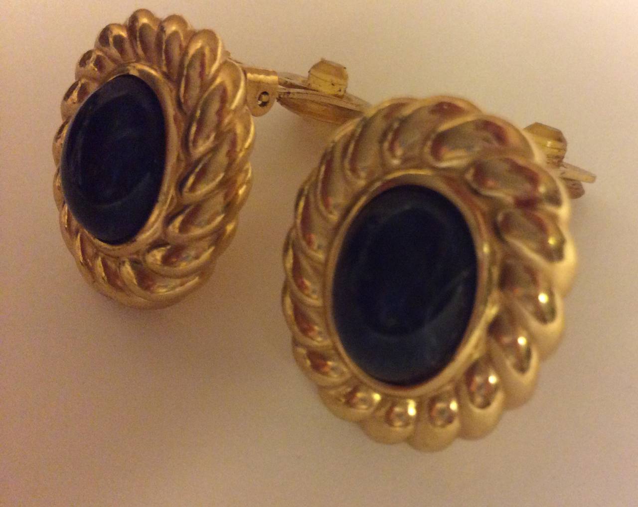 Vintage Christian Dior midnight sapphire oval cabochon with gold fan bezel chip on gold earrings.