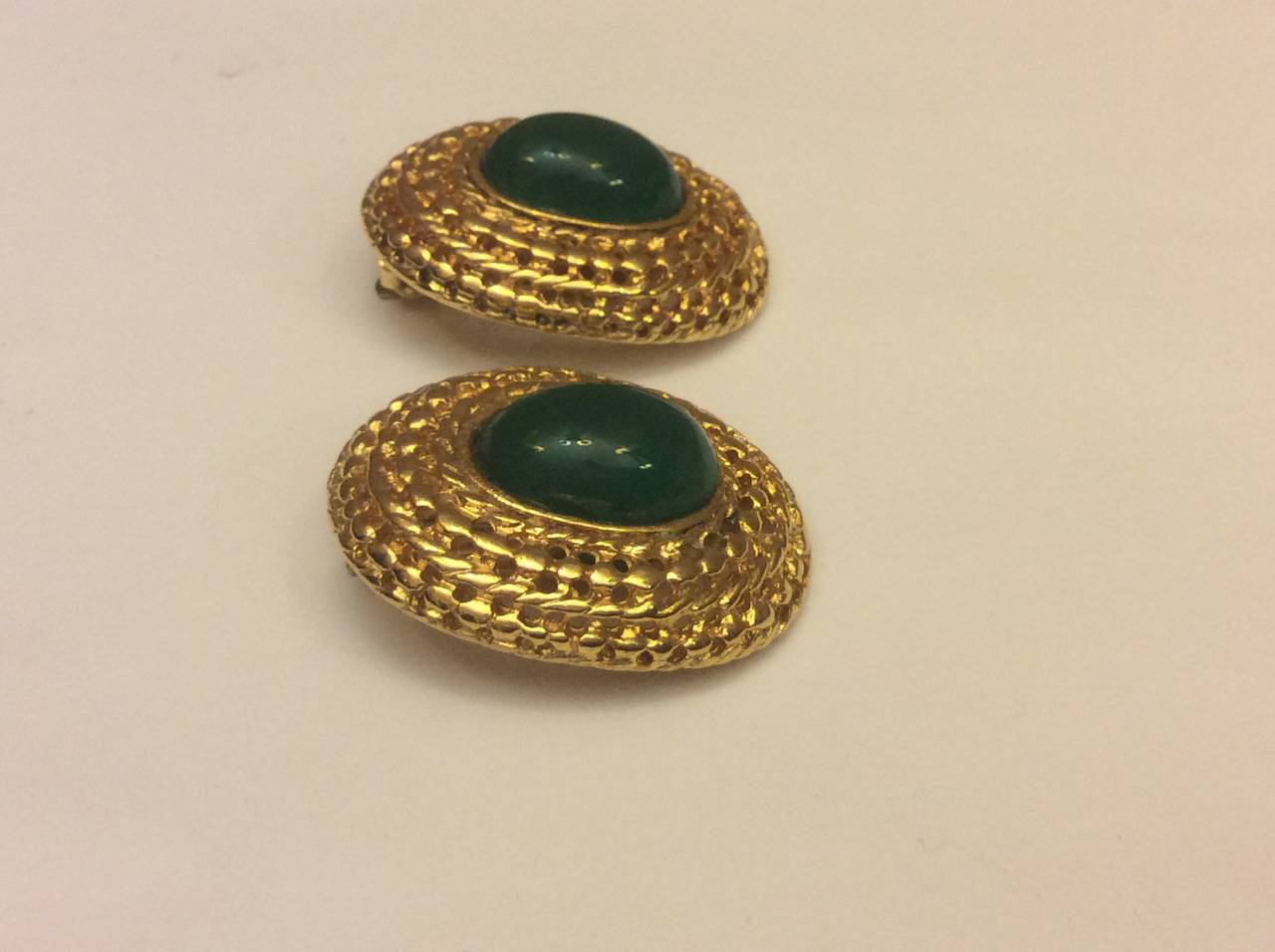 Vintage Les Bernard gold tone clip on earrings with faux emerald cabochon. 
Measure 1.5