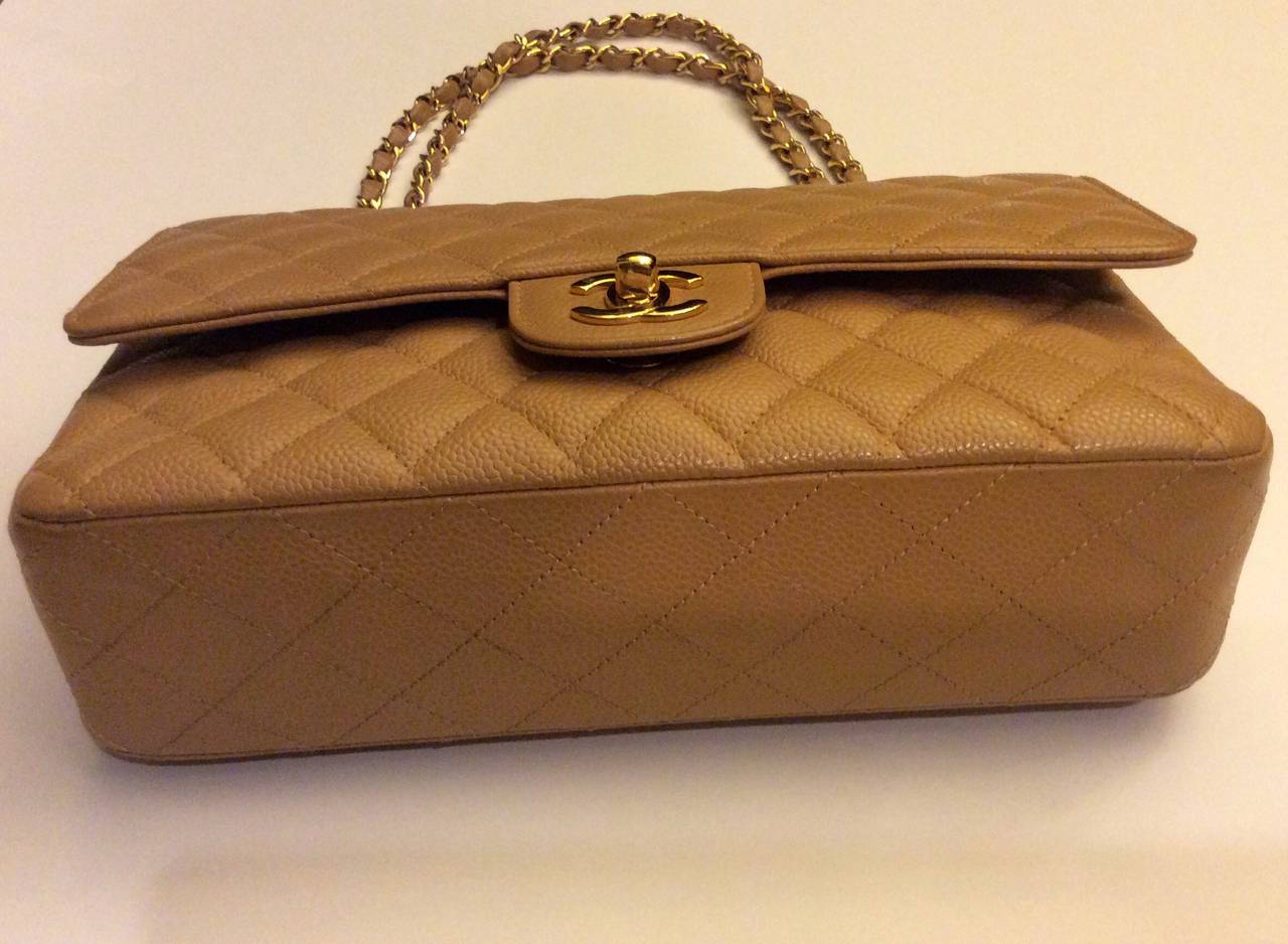 This Chanel 2.55 caviar leather double flap handbag with gold tone hardware
It is in excellent condition and comes with serial date code card, dustcover, and box.  Signature CC twist gold closure opens to a matching leather lined interior that