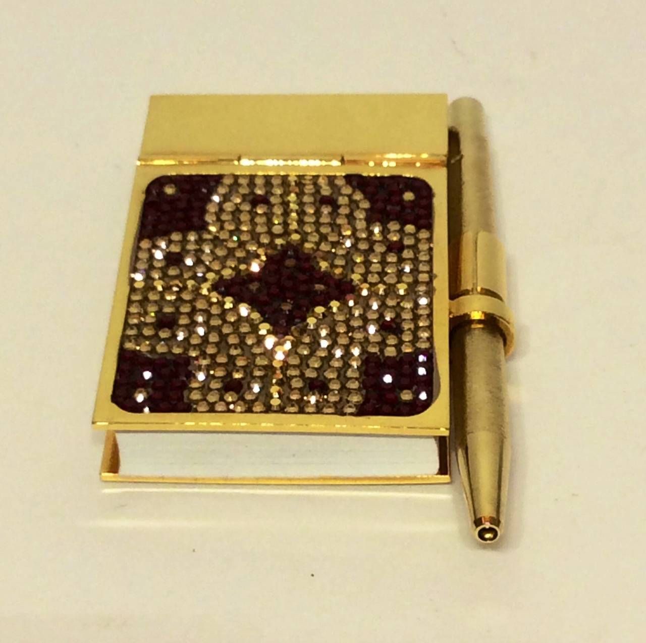 This us a sweet rare Judith Leiber mini gold notebook with Swarovski crystals & Pen
Gold-tone and gemstone embellished mini notepad with paper and pen.
Condition: good
Measurements: Length 2