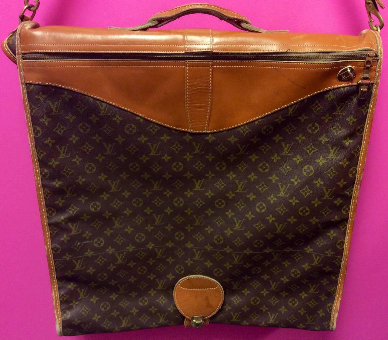 This is a rare vintage Louis Vuitton French Company monogram garment travel bag with shoulder strap. 2 exterior zipper compartments. 
Measurements:
50