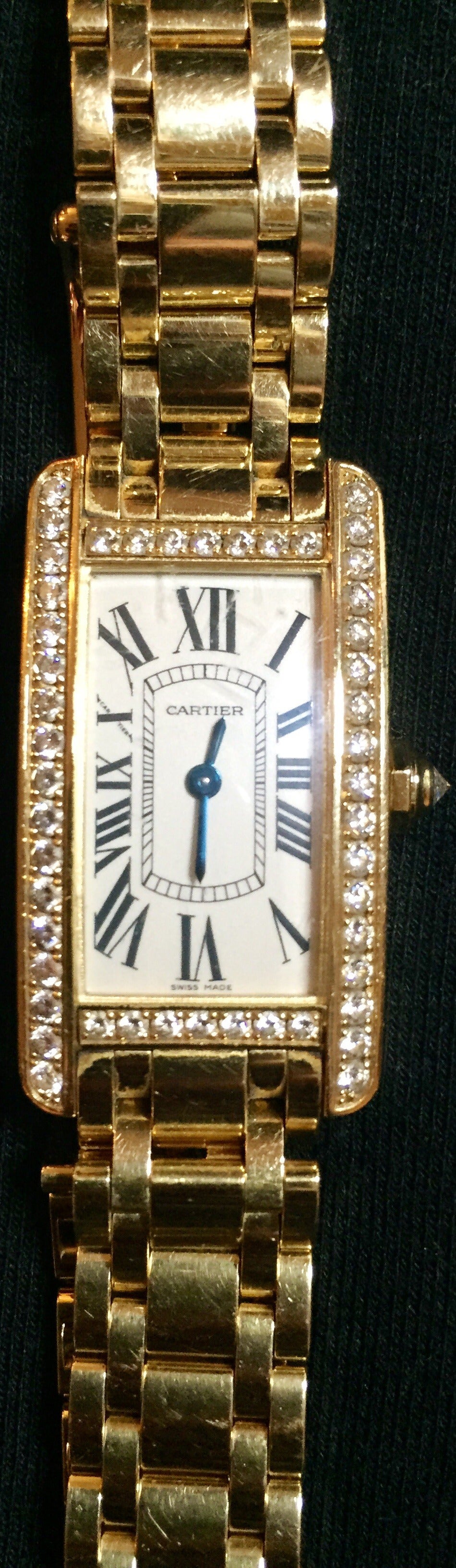 This is a gorgeous Cartier ladies 18k yellow gold watch with diamond case and Dial.
18kt yellow gold case with a 18kt yellow gold bracelet. Diamond bezel. Silver dial with sword-shaped blued steel hands and Roman numeral hour markers. Minute