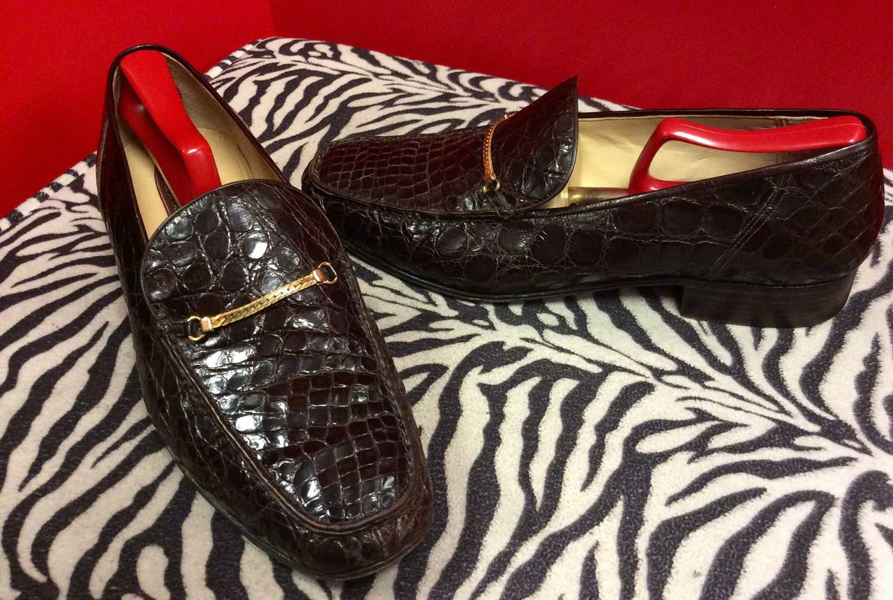 These are a beautiful pair of Bally Caiman Crocodile slip on loafer with gold chain detail. 
Size 10
Made in Italy