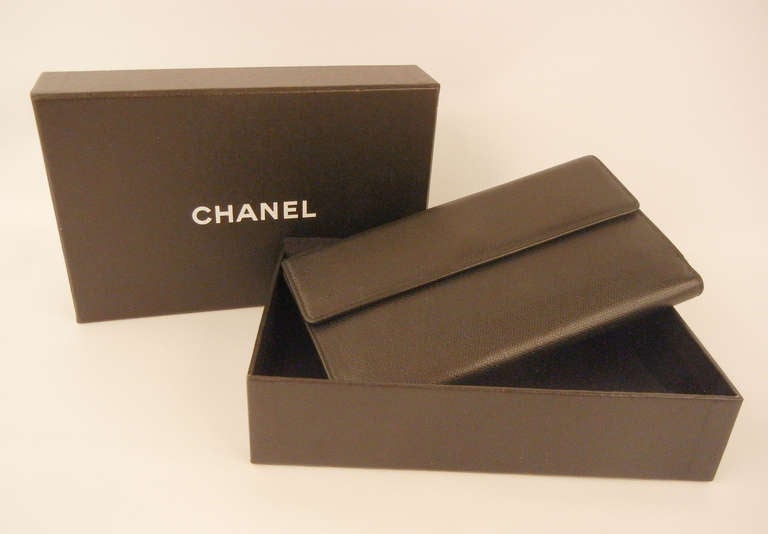 This is a Chanel black leather multi compartment long wallet. Perfect handbag accessory for the fashion conscious woman to organize essentials such as bills, credit cards and coins. Features black leather with a gold-tone tab snap closure with the