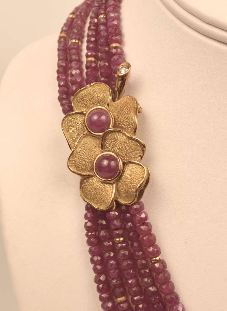 Spectacular Gioielleria Garanzia set!  The five strand, 16” necklace is fashioned in 18 karat yellow gold with sparkling, faceted Ruby roundels.  The double flower clasp features cabochon rubies and one brilliant cut diamond accent.  Matching flower