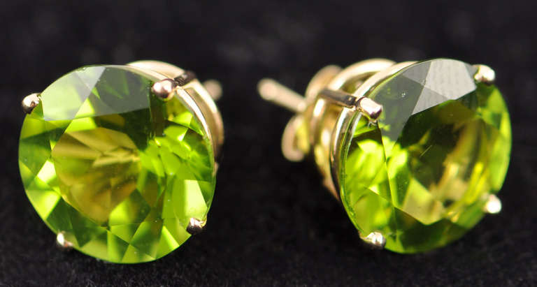 Gem quality Peridots set in 14 Karat Yellow Gold basket studs with a total weight of 14.24 carats.  These custom hand-made stunning bright green gems are believed to have magical powers and healing properties to bring the wearer power and influence.