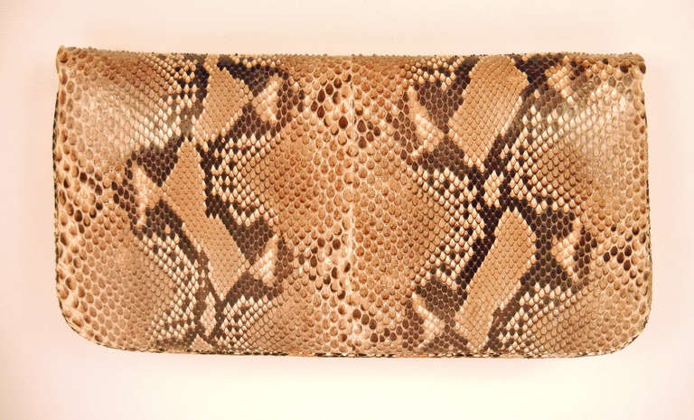 This Kara Ross handbag has a beautiful combination of python leather and glazed pink crocodile leather. The golden metallic and acrylic clasp on the front flap flips up to reveal a stunning soft beige leather interior with one interior zipper