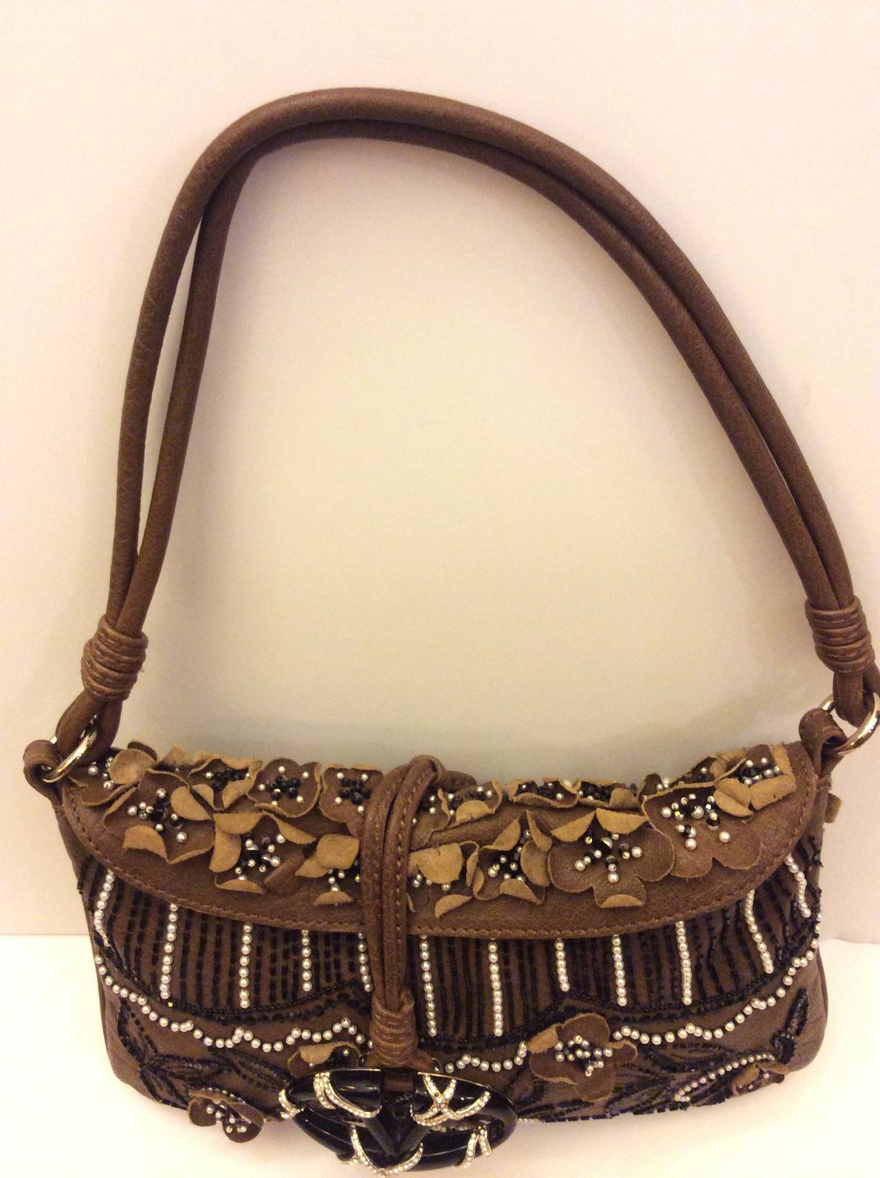 This is an absolutely stunning Valentino Garavani Brown leather evening handbag embellished with black beans and white pearls. Minimal flap closure with classic Valentino Swarovski crystal encrusted V toggle detail.  Beige silk lining. 
Made in