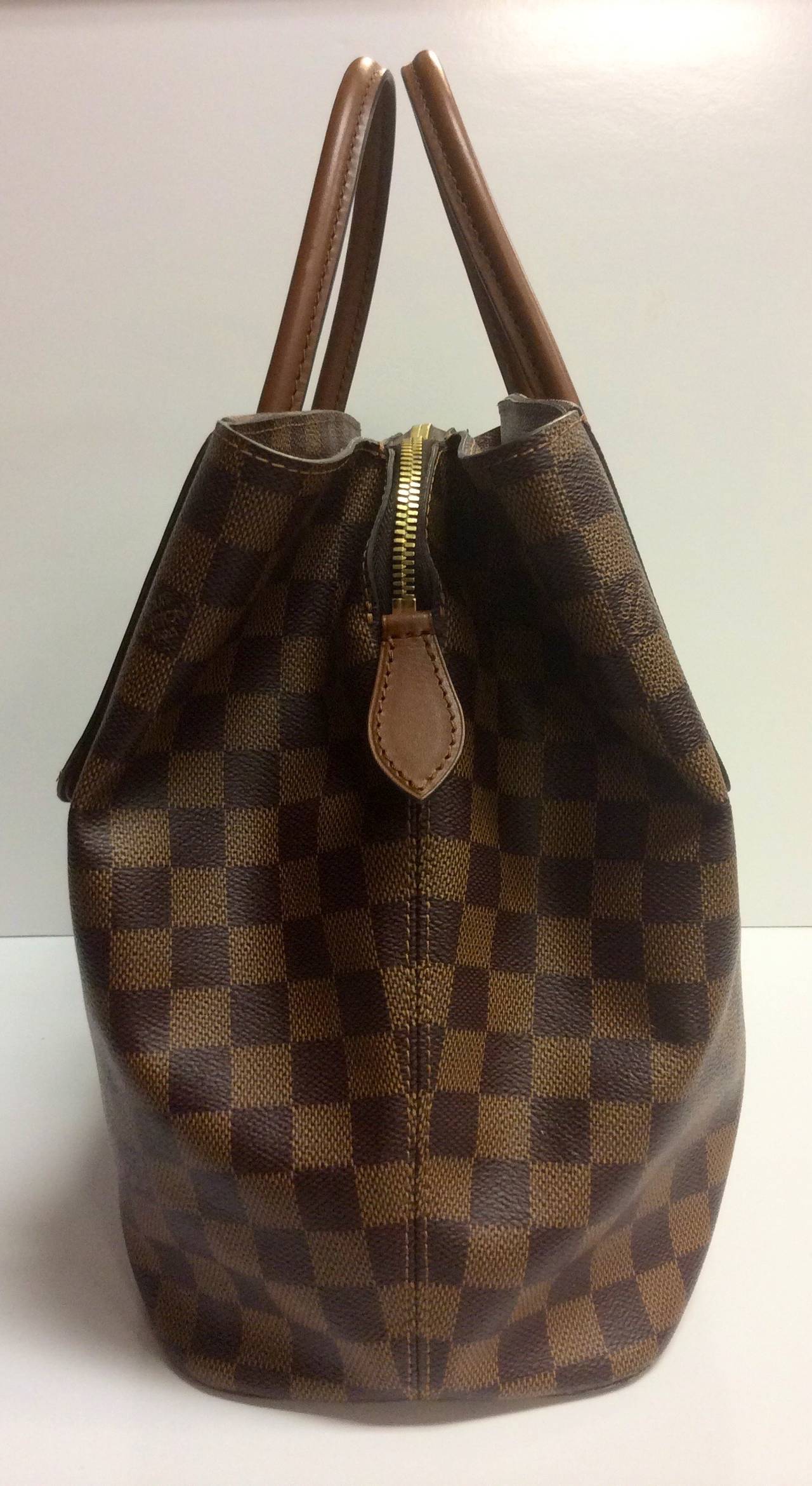 This is a Louis Vuitton Ascot tote handbag.
Crafted from an exceptional combination of Louis Vuitton's historic Damier canvas and Nomade calf leather, the Ascot bag is a sophisticated design whose elegant exterior conceals a roomy, compartmented