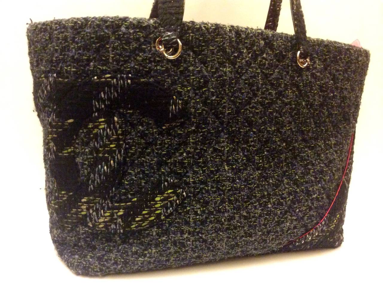 This is a Chanel Quilted Tweed large shopper tote bag.   This bag is in a quilted tweed and has a bright pink interior lining with zip closure. The bag has a open back exterior slip pocket, a large 'CC' in a contrasting tweed on the front of the