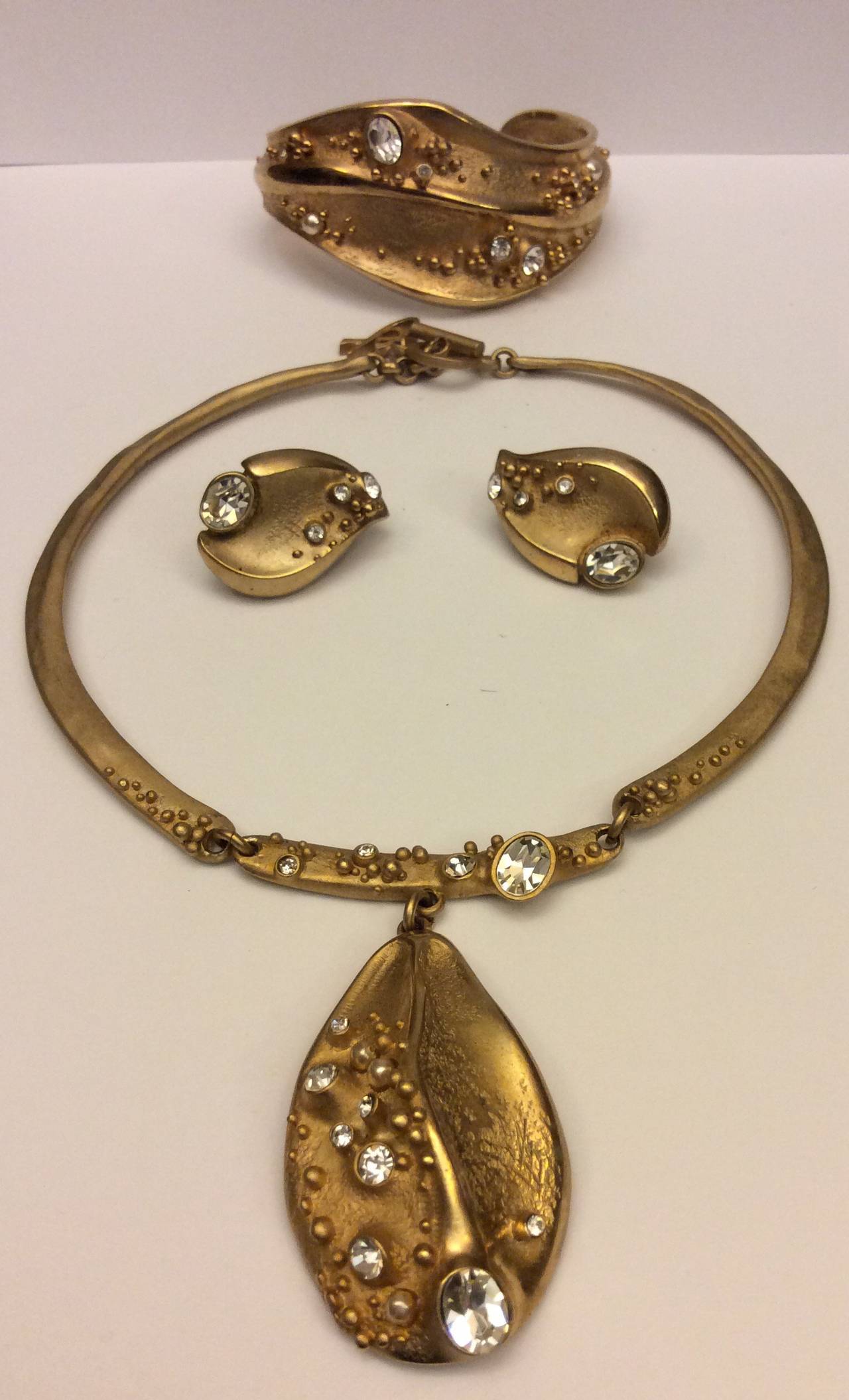 Stunning Christian Lacroix matching three-piece choker necklace, clip on earrings, and cuff bracelet.  Rustic gold with random float crystals. 
Perfect Condition
Necklace 16