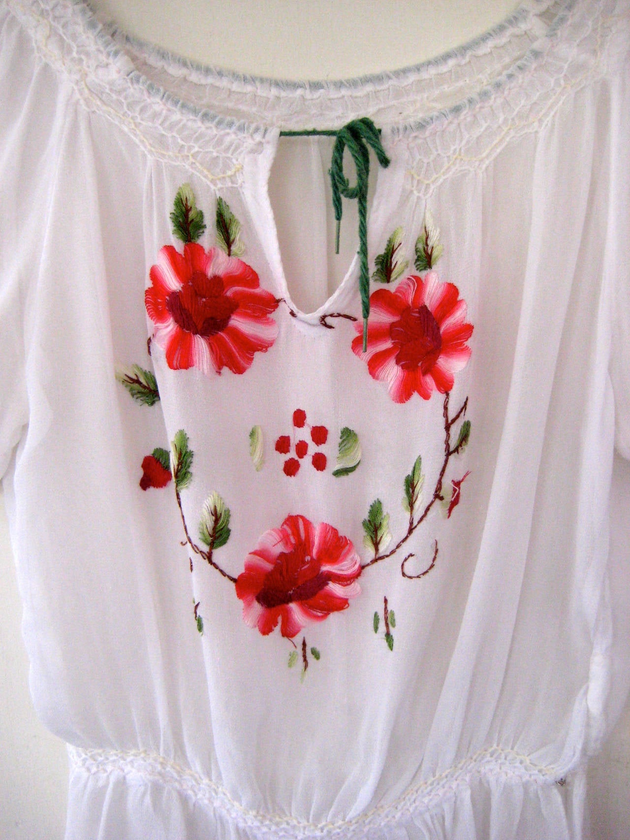 Exceptional hand embroidered peasant blouse .This dates to the 1930s and it is smocked at the bodice and the waist 

True drawstring at the neckline .Lovely embroidered flowers .Fabric appears to be silk crepe or perhaps a blend of silk and cotton