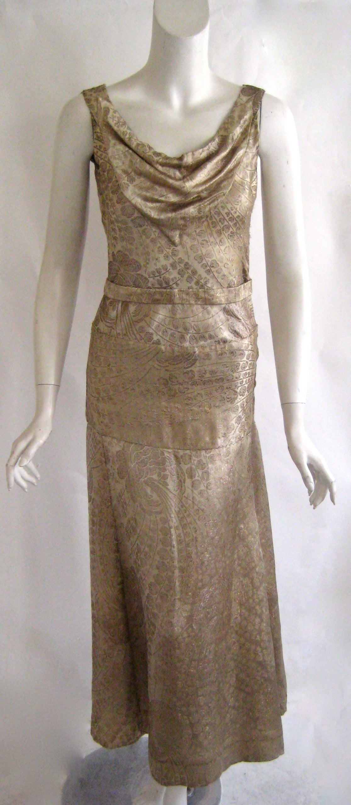 1920s silk lame evening dress with cowl neckline and attached self belt ,This closes up one side with snaps and there are no other closures.This is put together in 3 sections with bodice , skirt and  a wide swath of fabric at the hip area .The