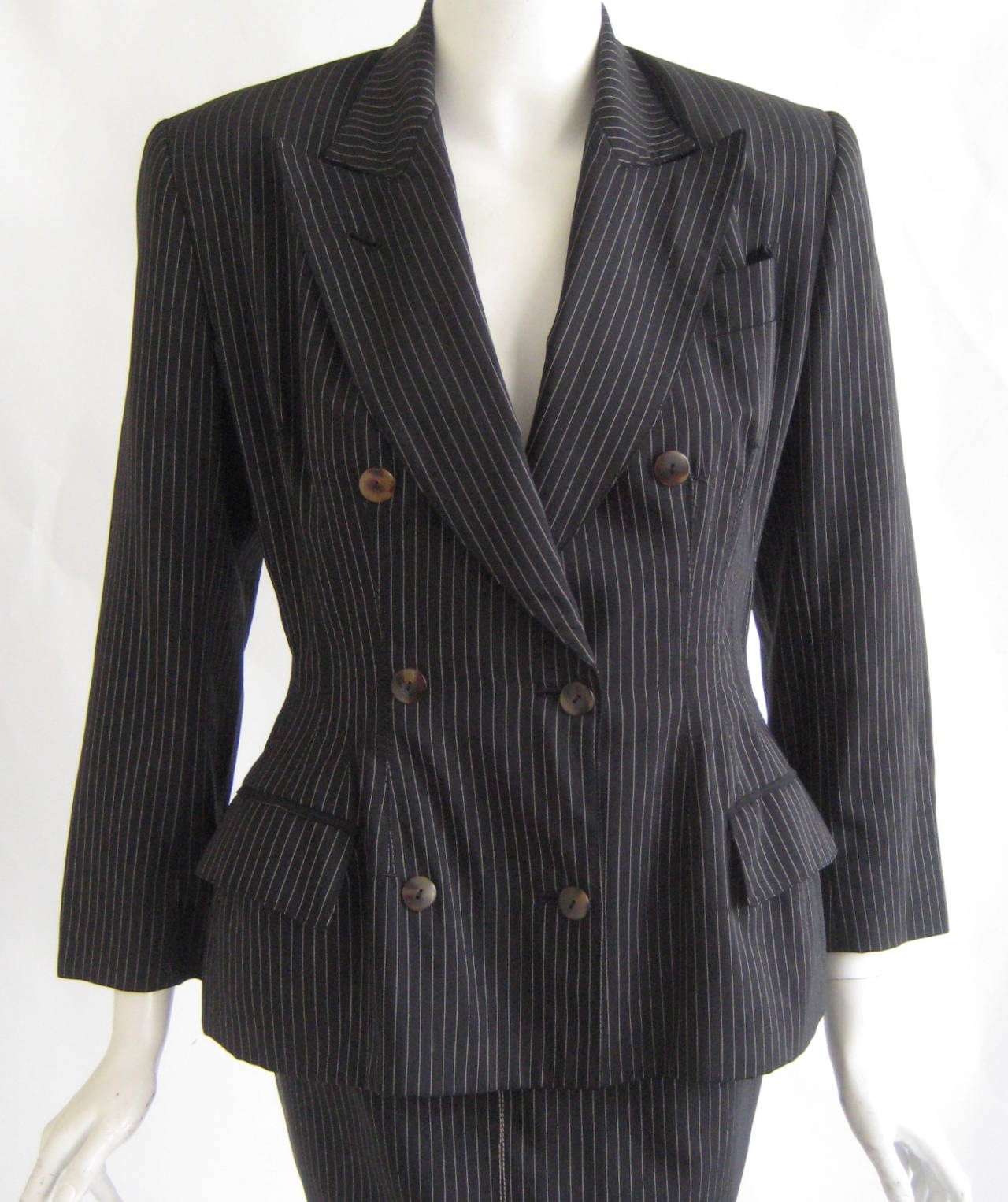 Wonderful early Gaultier suit
Fine pinstripe wool with beautiful printed silk lining
Nip waist and two functioning front pockets
Pencil skirt zips up the back and fastens with one hook and eye
Truly a beautiful piece.This was originally sold at