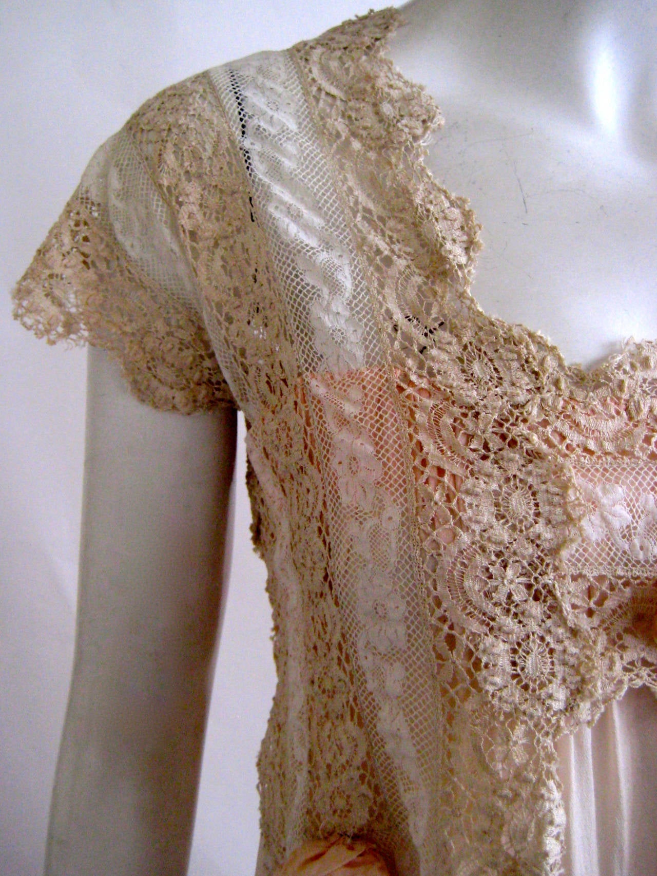 Fine palest pink silk with handmade irish crochet lace bodice.
3 pale pink flowers with silk centers adorn the lace
Cap sleeves
This snaps up on the left side of the bodice indicating that this was probably designed for a new mother.