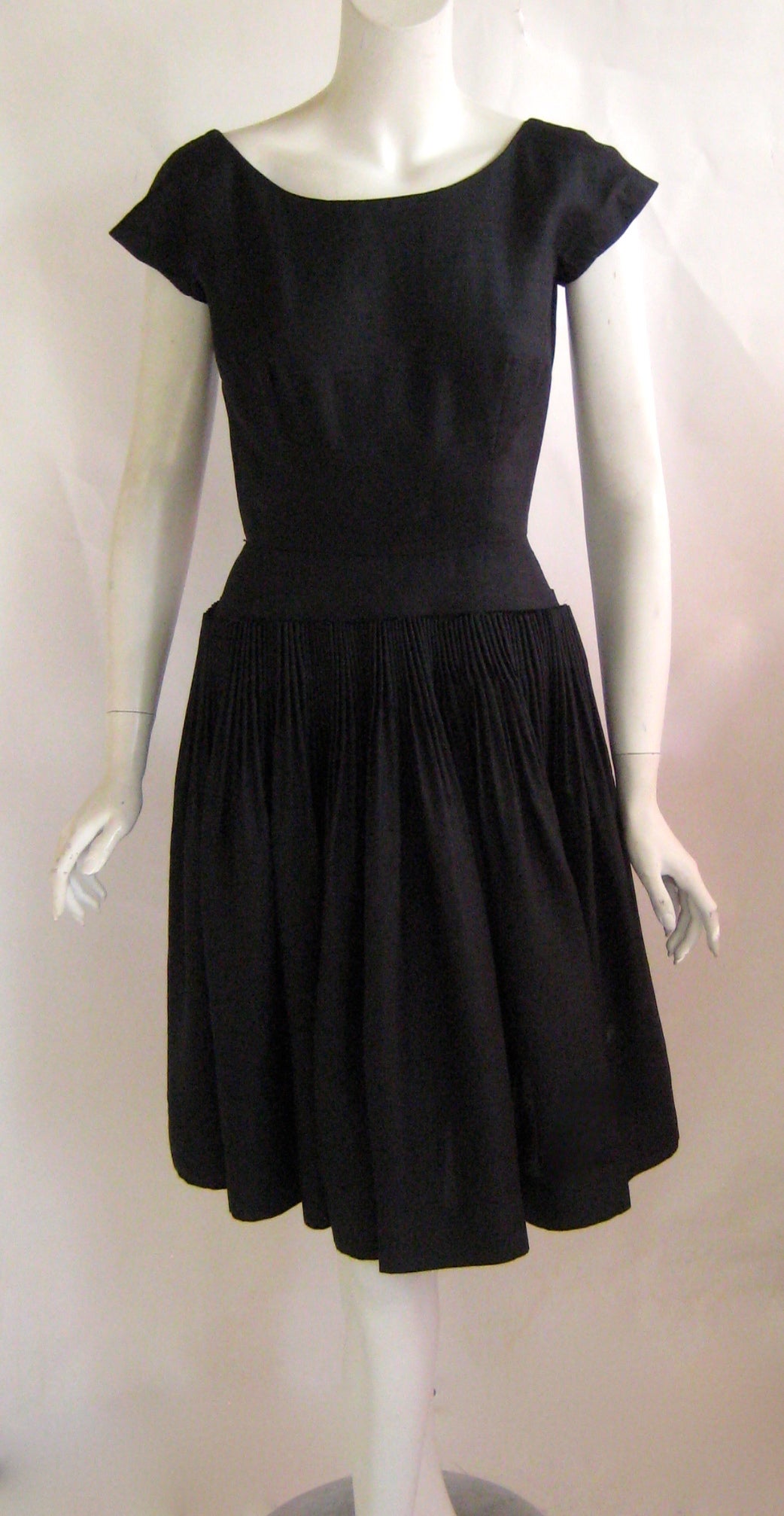 Perfect little black dress by Karen Stark for Harvey Berin.This is made of 100% raw silk and the skirt is cartridge pleated all the way around .THe bodice buttons up with 2 large plastic buttons and the there is short metal zip in the back of the
