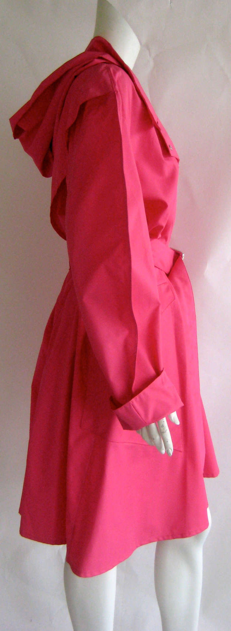 Fabulous hot pink Thierry Mugler raincoat with detachable hood
Snaps up the front with pink snaps
Hood snaps on and off
Matching self belt
2 side slant pockets close with snaps
Polymide /rayon combo
Unworn dead stock piece .This still has the