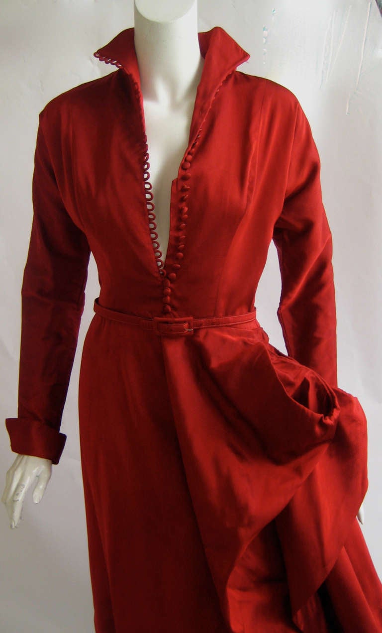 Amazing Ceil Chapman cocktail dress
Red silk with a black warp.
Fabric looks and feels like a matte taffeta sharkskin
Wired semi panniers to one side 
Tiny metal zipper up the side 
Tiny silk covered buttons up the front
Thin matching belt