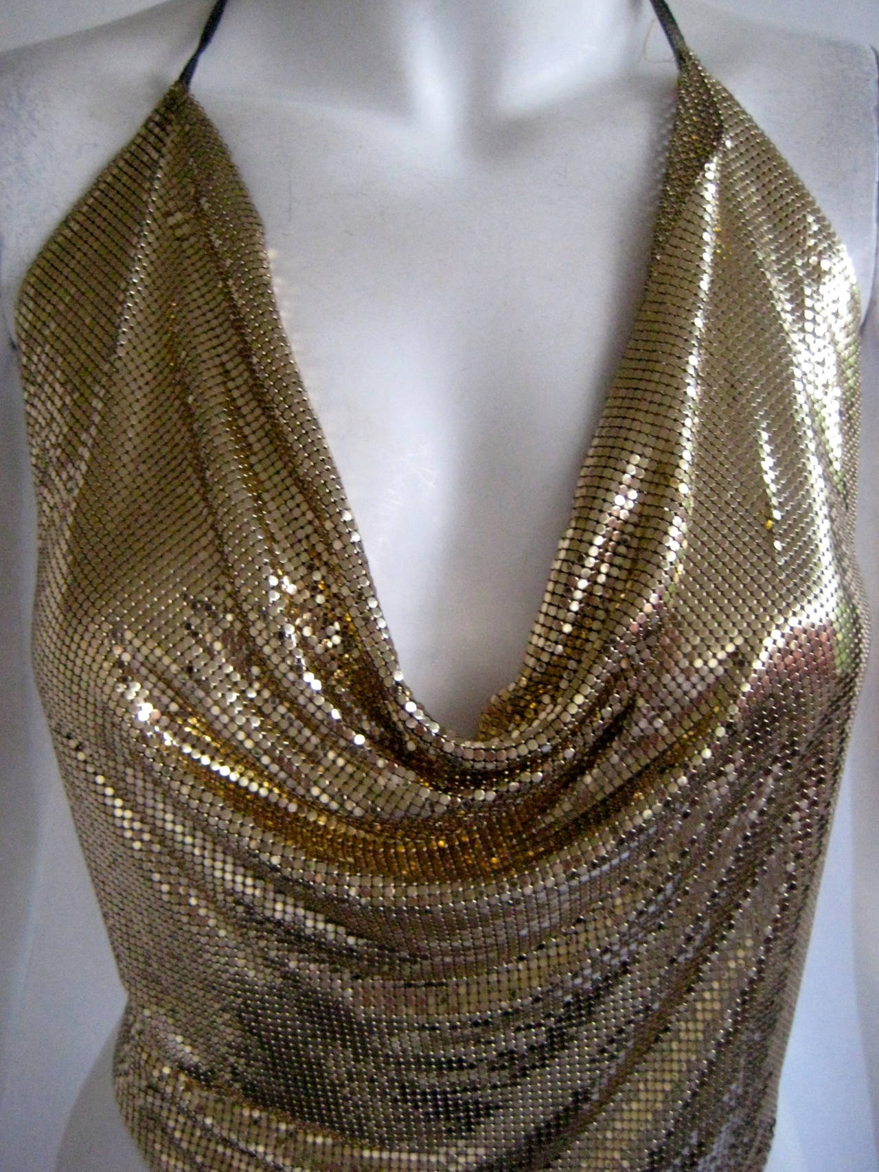 Killer metal mesh disco top ties with leather ties at the neckline and waist .Top drapes and is cut in a point on the bottom .This is in excellent condition and bears no label.This top measures 19