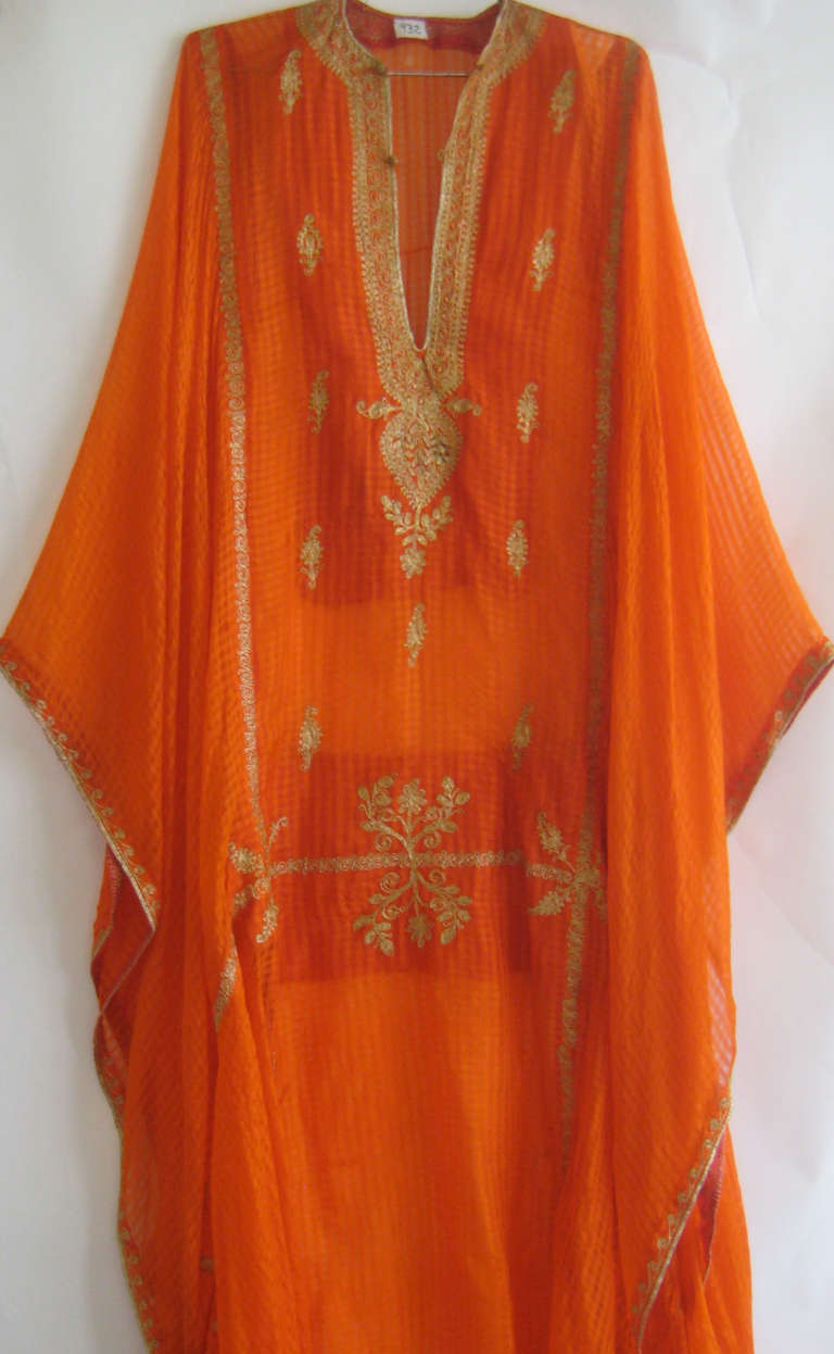 Early striped silk caftan with delicate gold chain stitch embroidery.The is cut is a T formation with very wide sleeves that leave it open down the sides .Silk is semi sheer and very beautiful.

Best for study or display.Museum tag at neckline