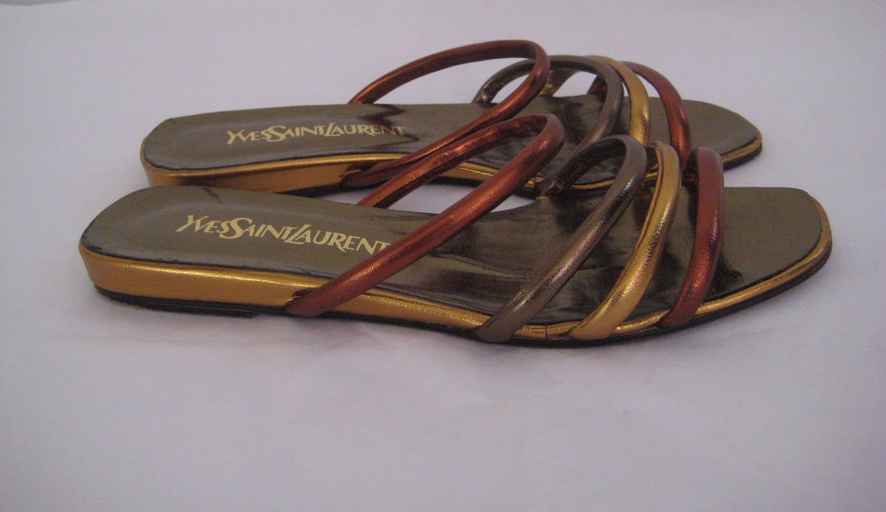 Yves saint Laurent sandals in gold and bronze leathers .Labeled size 6 1/2 medium .Made in Italy .There is some wear to the soles but the leather is in excellent shape