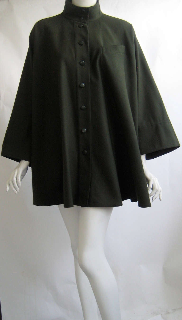 Chloe cape coat with wide short sleeves.
100% wool
Buttons down the front with matching green buttons.
No pockets