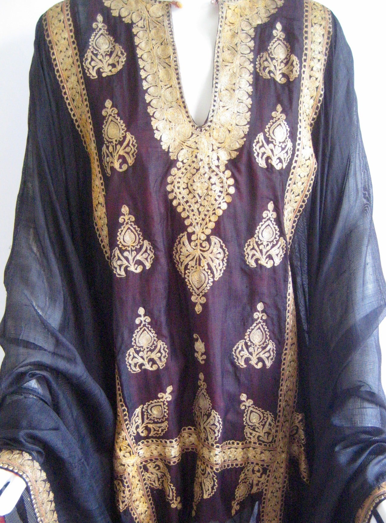 Amazing Middle Eastern Caftan .I believe this originally came from the Bahrain Islands.It was de accessioned at auction from a history museum and looks as it was worn very little if at all .
Made from very fine woven striped silk this has gold